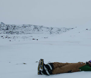 Expeditioner laying on a frozen lake