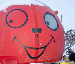 Round, red fibreglass hut with a smiley face painted on