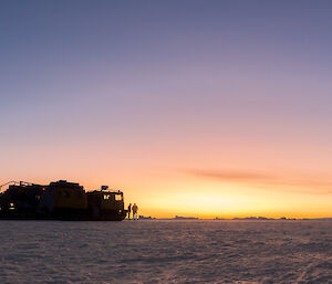 Two Hägglunds and three photographers take in a stunning sunrise on the sea ice