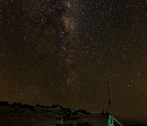 Millions of stars above a green hut