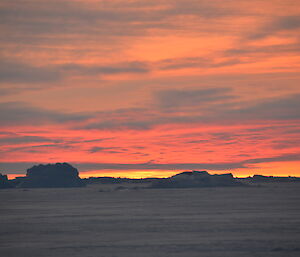 Bright red sunset with ice bergs in the foreground