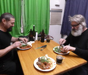 Two expeditioners at the dinner table eating dinner