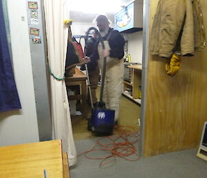 Expeditioner vacuuming the floor of the hut