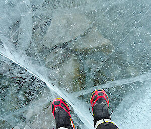 Photo looking down into the lake, expeditioners black boots in the photo