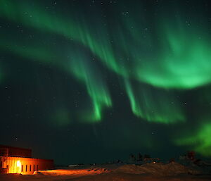Bright green aurora in the sky over station buildings