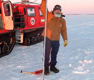 Expeditioner holding a two metre long ice drill