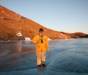 Expeditioner standing on a smooth bright blue frozen lake