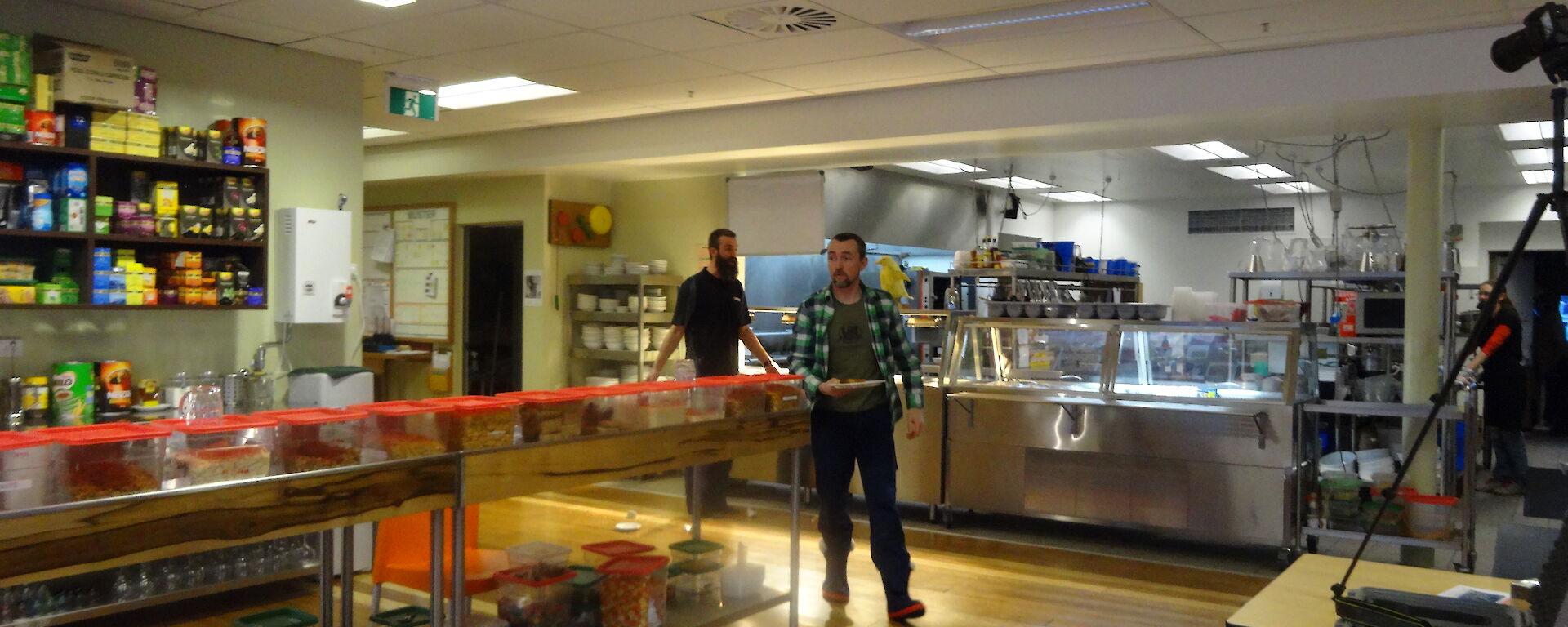 Two expeditioners walking towards a video camera in the kitchen