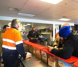 Expeditioners listing to instructions in the mess