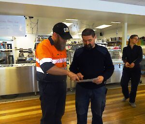 Two expeditioners looking at a map of the station