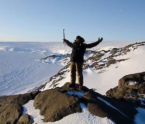 Expeditioner standing on top of a rocky hill