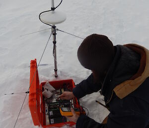 Expeditioner testing electonics in small red case