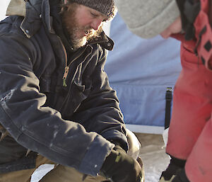 Two expeditioners holding an ice drill