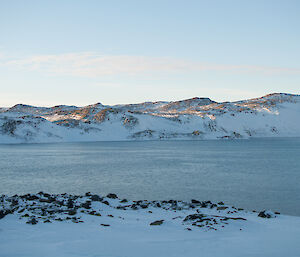 A lake surrounded by snow capped hills