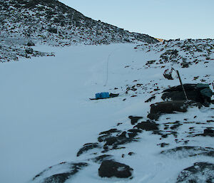 Blue containers on a sled at the base of a valley