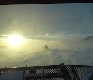 Photo taken from inside vehicle looking out at the blowing snow