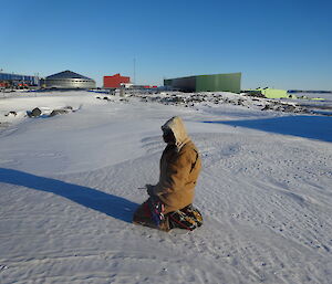 Expeditioner blindfolded kneeling on the icy ground