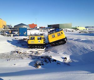 Yellow Hägglunds vehicle parked in a small ditch