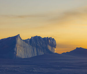 Bright yellow sunset with icebergs in the foreground