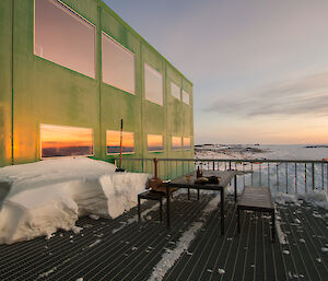 table and chairs on a metal verandah overlooking sea ice