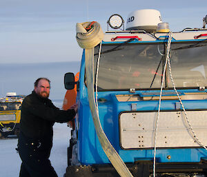 Expeditioner leading against a blue Hägglunds