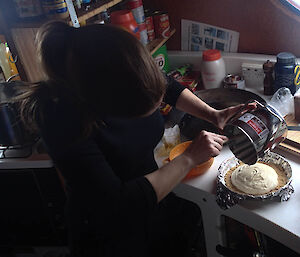 Expeditioner pouring the filling on to a biscuit base