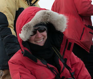 Close up photo of expeditioner wearing red jacket and sun glasses