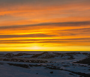 Stunning bright yellow and red sunset over the sea ice