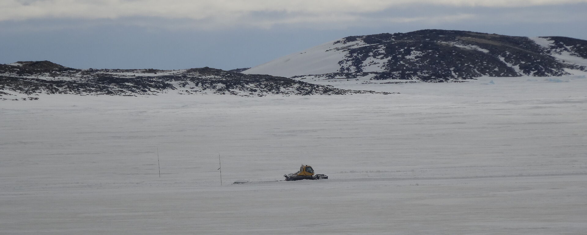 Groomer on the sea ice on driving along a cleared section of the ice