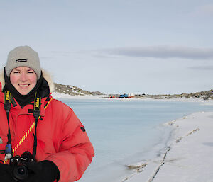 Close up photo of expeditioner with flooded frozen fjord in the background
