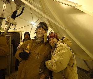 Two expeditioners posing for a photo in the middle of a dome