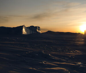 Sun setting between icebergs