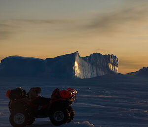 Side of an ice berg lights up as the sun sets