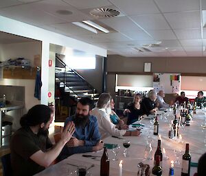 20 expeditioners seated at a formal dinner table