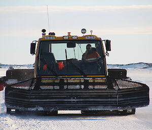 Expeditioner in the cabin of a large snow groomer