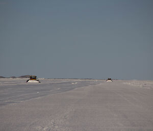 Two snow groomers pushing snow