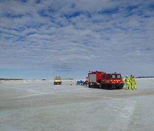 Expeditioners dressed in fire turn out gear exit the fire hagglund