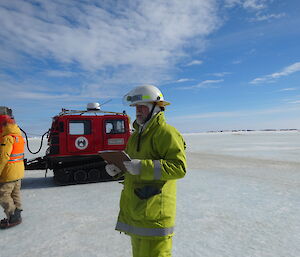 Expeditioner dressed in fire fighting kit holding a clip board