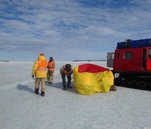 Injured mannequins under a red and yellow bivy