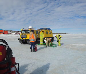Expeditioners mopping up a green patch on the sea ice