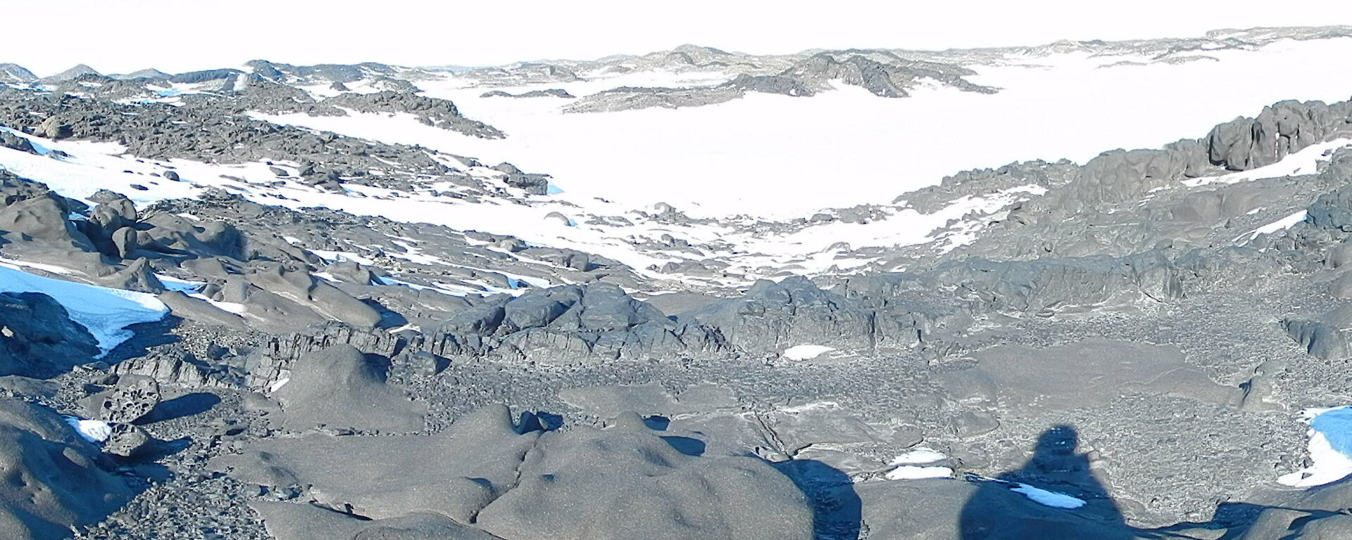 Photo of four expeditioners in the distance standing on Barrier Island