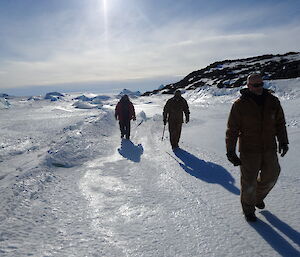Three expeditioners walking on sea ice