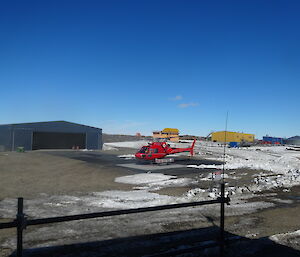 Red helicopter on a heli pad