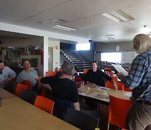 Expeditioner speaking to a group of expeditioners sitting at table