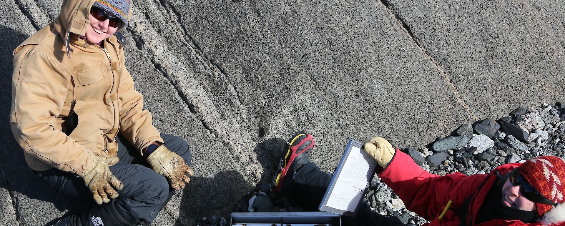 Two expeditioners opening up a cache