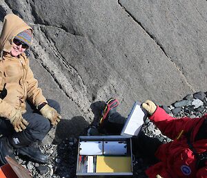 Two expeditioners opening up a cache