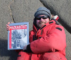 Expeditioner holding up an old framed photo of a Geographic magazine cover