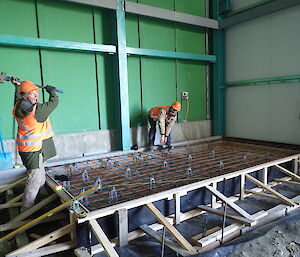 Tradesperson holding sledgehammer above formwork