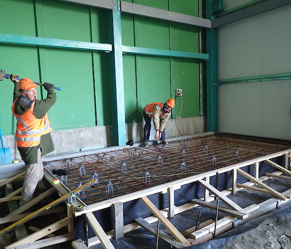 Tradesperson holding sledgehammer above formwork