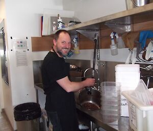 Man standing in a kitchen facing camera